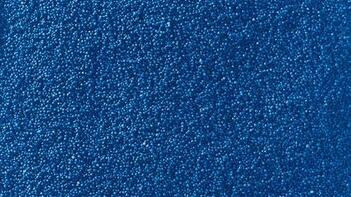 Kleine blaue Kügelchen dicht aneinander liegend. (automatisch generiert durch KI)