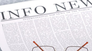 Brille liegt auf einer Zeitung mit der Überschrift INFO NEWS. (automatisch generiert durch KI)