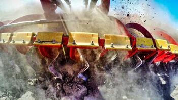 Nahaufnahme eines landwirtschaftlichen Pflugs, der Erde aufwirbelt und Staub erzeugt. (automatisch generiert durch KI)